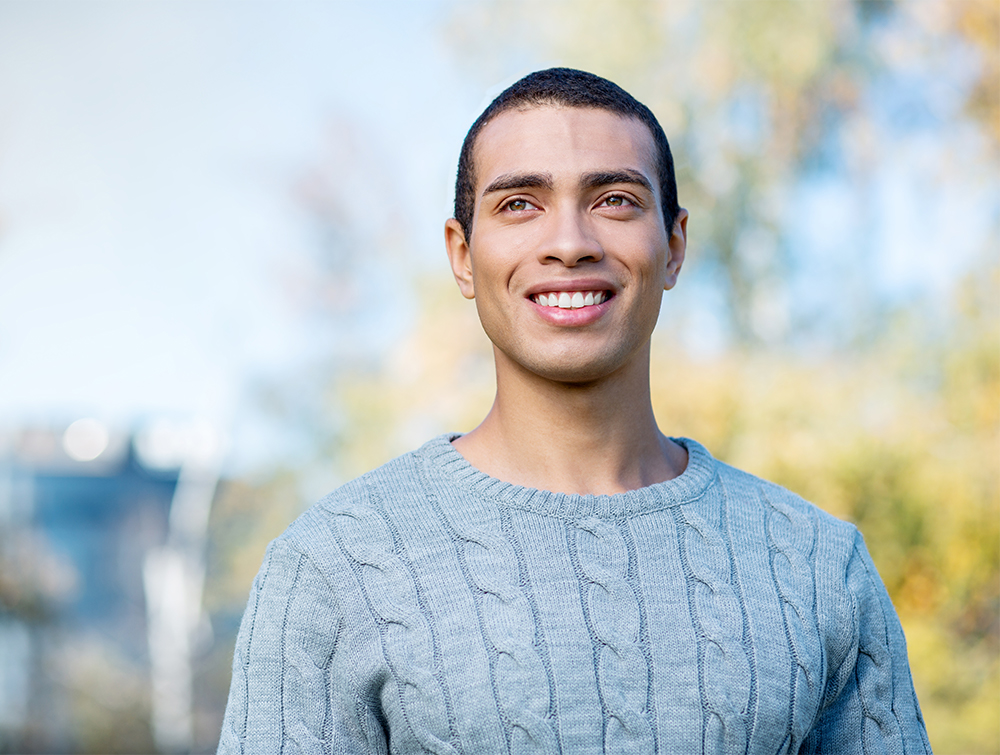 Confident young man smiling outside showing healthy natural teeth – Dentist in Tustin CA